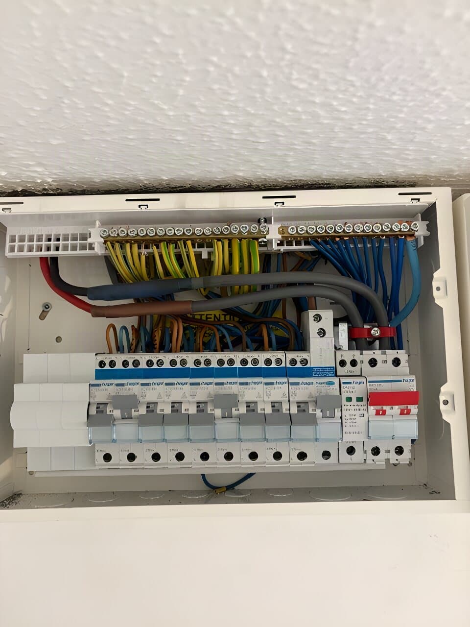 Consumer unit with the cover off, showing neatly dressed cables